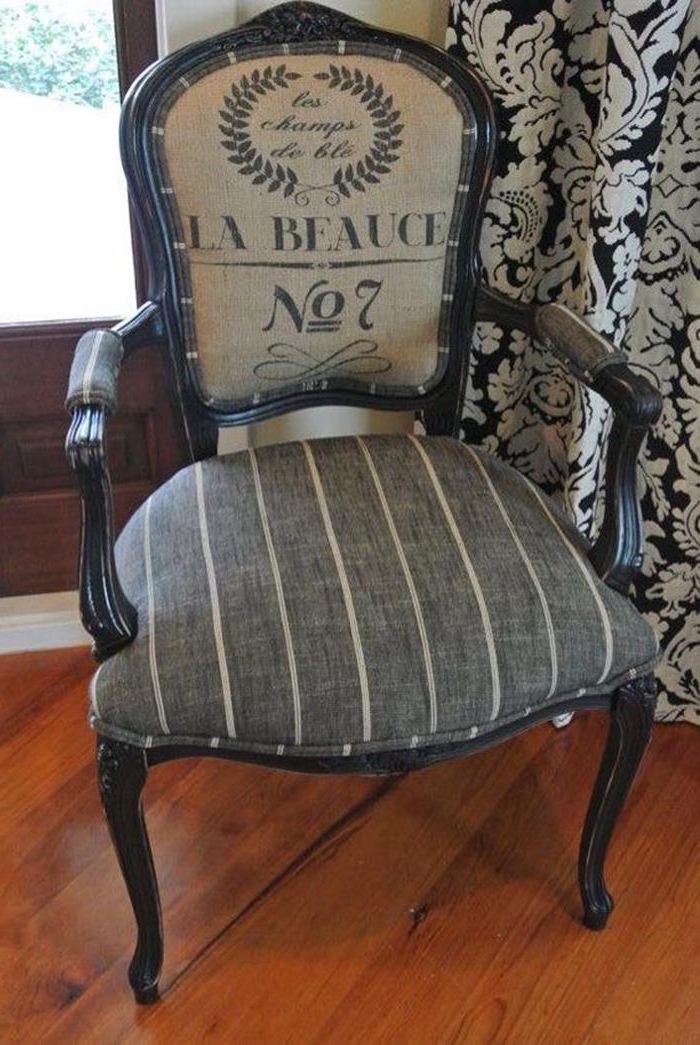 dark grey chair with cream stripes, graphic print on its backrest, black legs and armrests, vintage french style