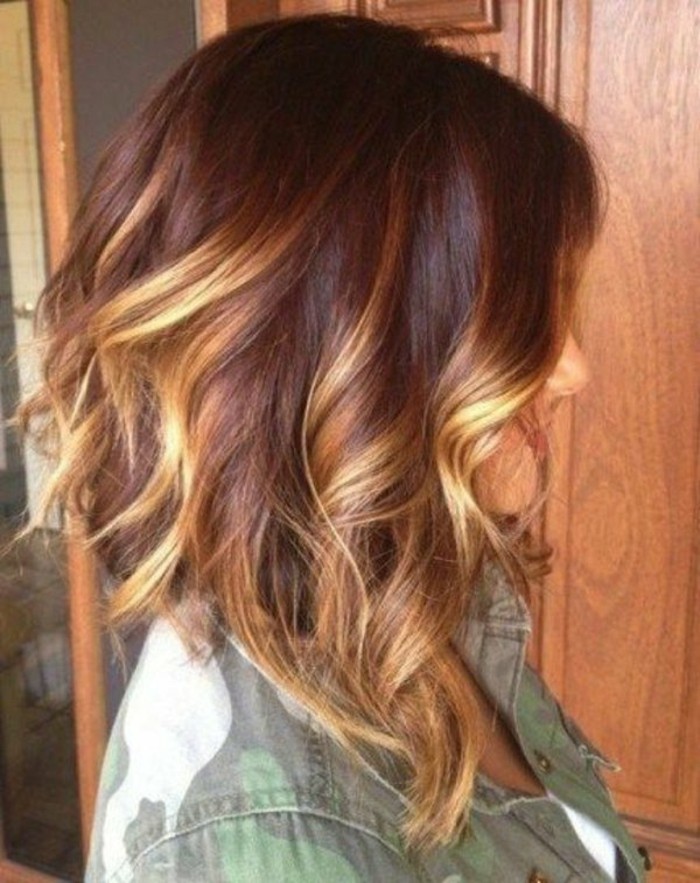 light blonde highlights, on curled medium length brown hair, worn by woman, dressed in camouflage patterned shirt