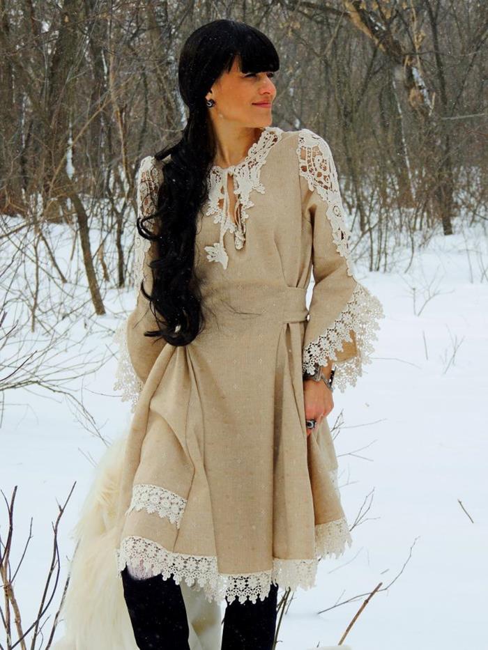 beige boho chic dress, with white lace trim, on woman with knee-high black boots, and long black hair with bangs