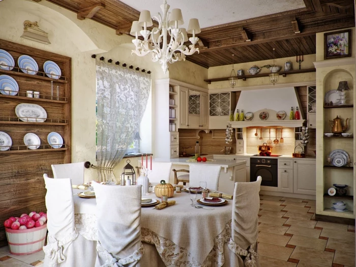 spacious kitchen with tiled floor, old-fashioned black stove, round table covered with beige fabric, and six matching chairs, shabby sheek interior