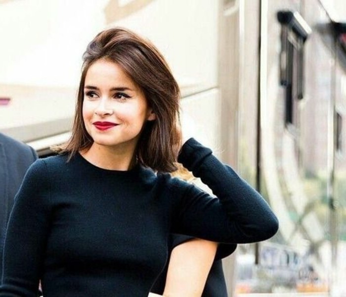 red lipstick and black mascara, on smiling woman, with shoulder-length haircut and medium brown hair color, wearing a black jumper