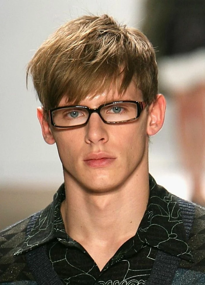 glasses and a patterned shirt, with silver threads, on young man with glasses, and blonde layered hair, with choppy bangs falling on his forehead
