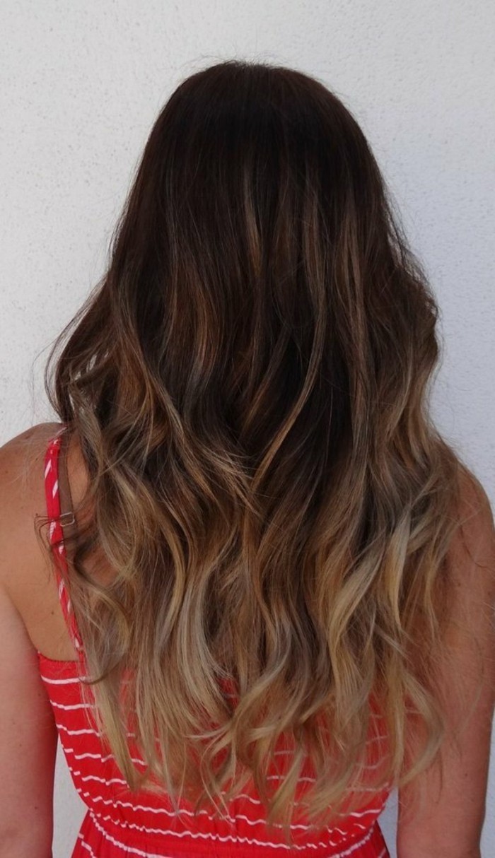 red strappy dress, with white stripes, on brunette woman with curled, brown highlighted hair, with blonde balayage