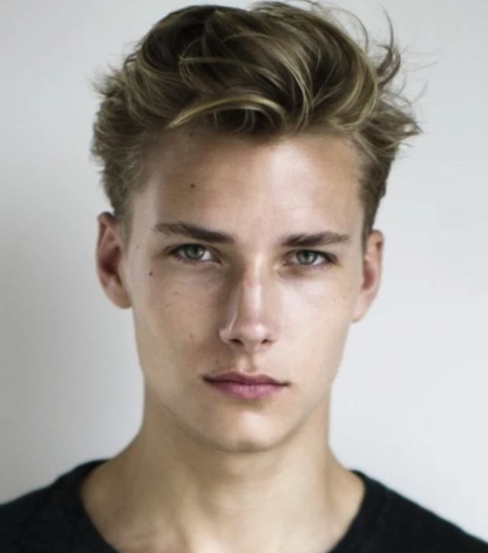 hairstyles for teenagers, blonde young man, with a semi pompadour style hair, bangs combed over to one side, wearing black top