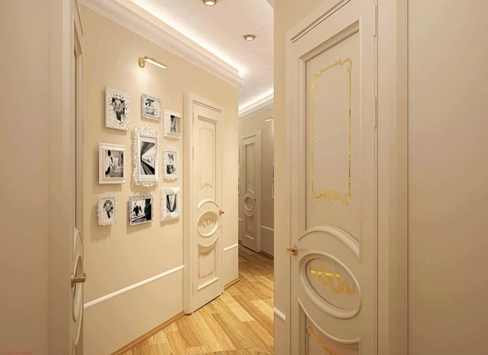 pale cream walls and doors, with plaster details, and golden decorations, hallway decor, light wooden floor, several white frames on wall