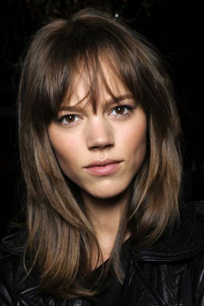 discreet make up, worn by brown-eyed young woman, messy layered hair and fringe, medium length brown hair, black leather jacket