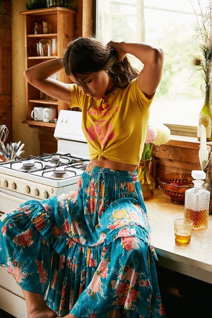 teal tiered maxi skirt, with pink and yellow floral pattern, combined with yellow and pink shirt, bohemian style clothing, on rebellious brunette woman