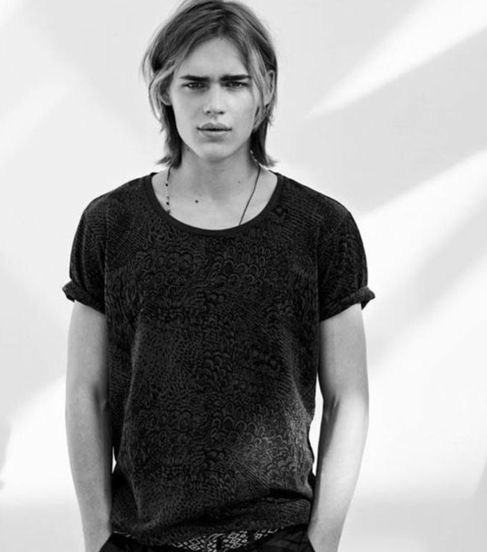 long hairstyles for boys, black and white image, of teenage boy wearing patterned t-shirt, with layered blond hair, very natural look