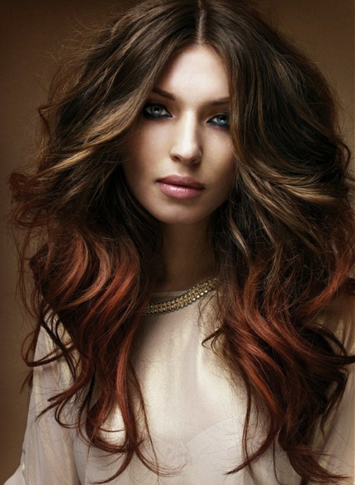 pink lipstick and dark eye make up, on woman in white shiny top, with golden necklace, medium length brown hair, messy wavy and partially dyed red