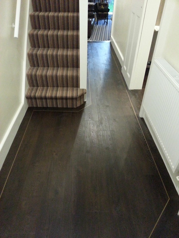 dark solid wood floor, near white walls and door, hallway decorating ideas, narrow staircase, covered with striped rug, in different shades of brown