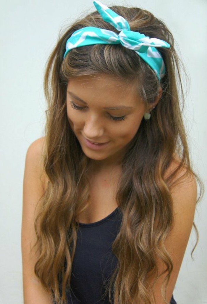 dimpled girl with discreet make up, and long wavy brown hair, with dark blonde highlights, wearing black tanktop, and teal and white headband