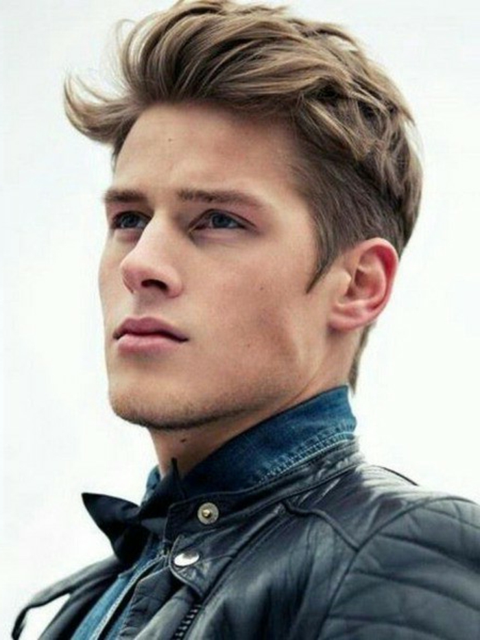 cool haircuts for boys, young man with dark blonde hair, messy pompadour style, wearing black leather jacket, and denim shirt