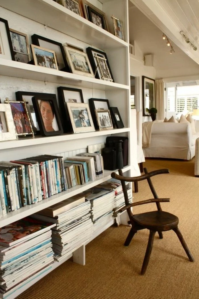 books and many framed photos, on white shelves, near a small wooden chair, hallway furniture ideas, beige carpet