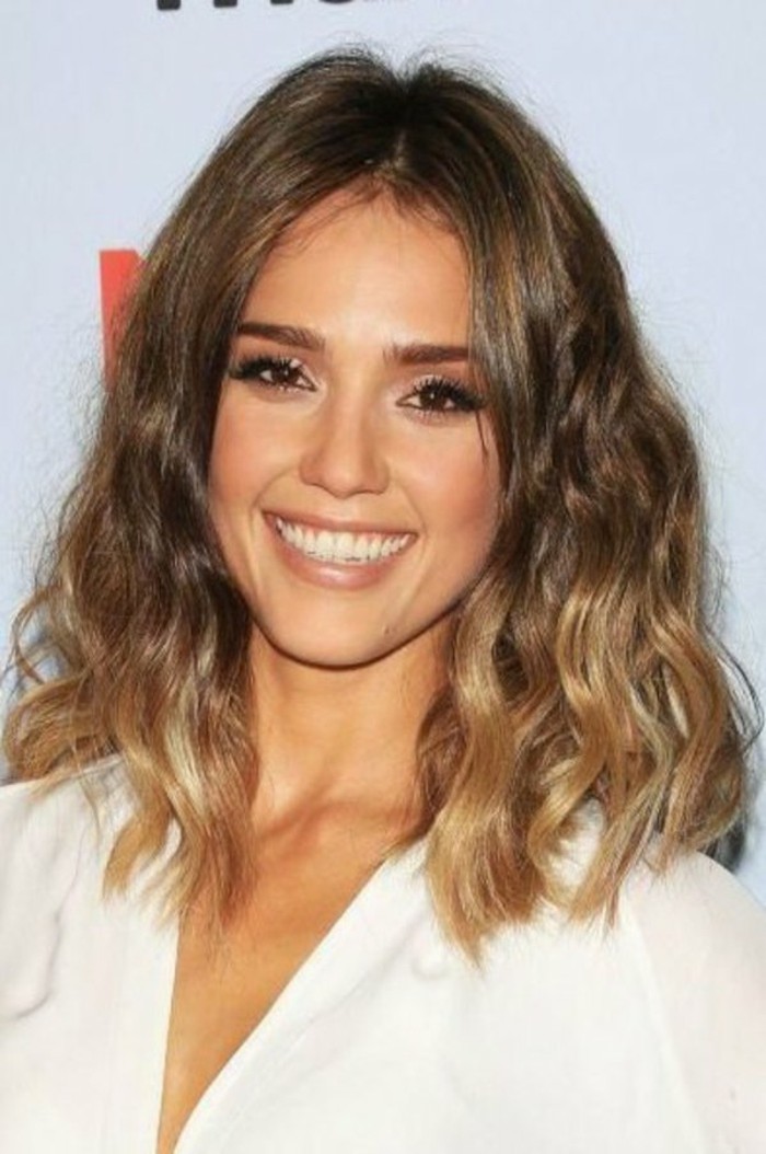 white v-neck top, worn by smiling jessica alba, with black mascara and nude lipstick, medium length brown hair, with blonde highlights