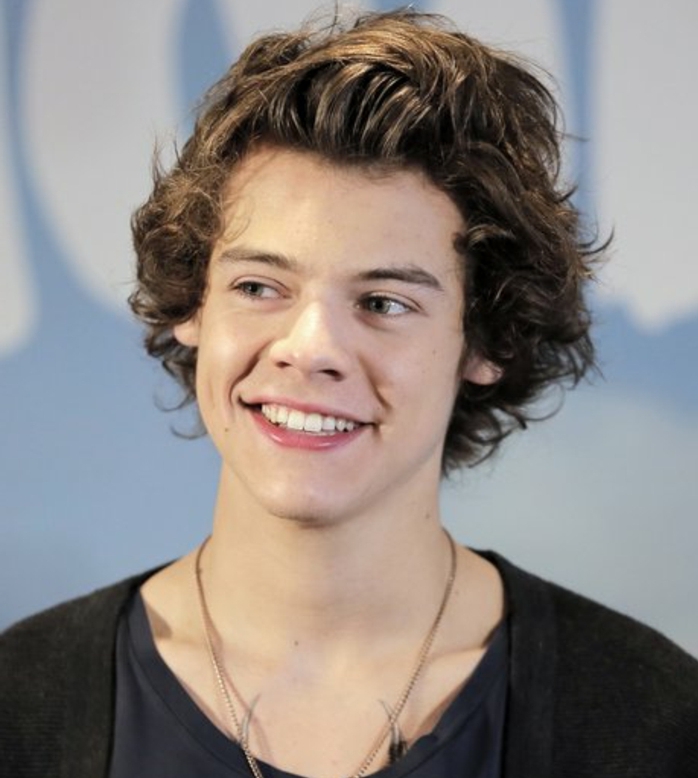 chin-length shaggy, curly and messy brunette hair, with bangs partially brushed back, worn by a smiling harry styles