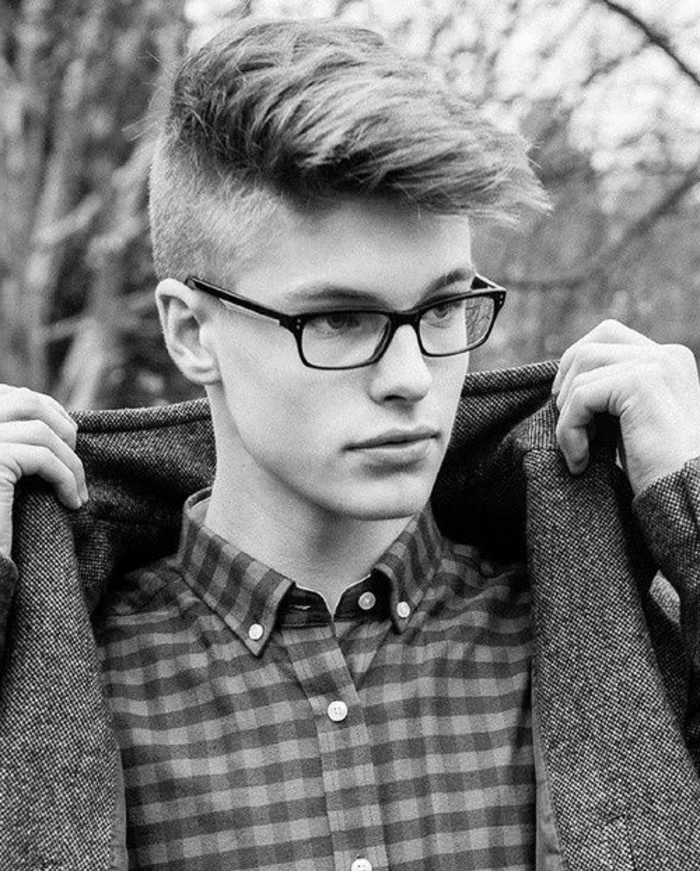 disconnected undercut, boys fade haircut, with faux hawk, on teen with hipster glasses, wearing checkered shirt and woolen coat