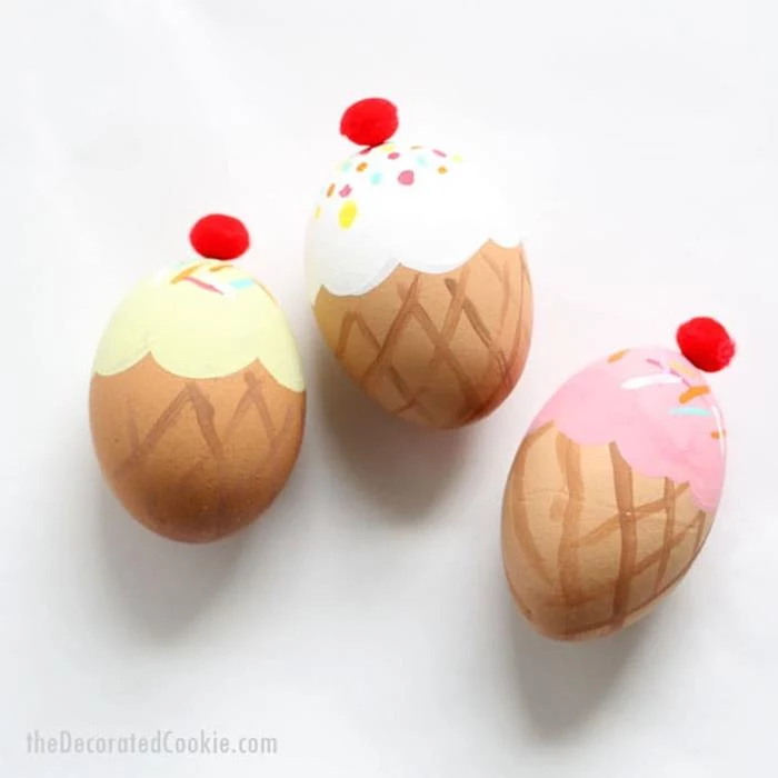 hand-painted easter eggs, made to look like ice-creams, decorated with red pom-poms on top, easter egg ideas, on white background