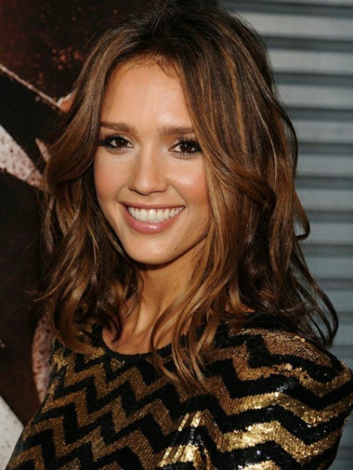 sequin top in black and gold, worn by smiling jessica alba, with wavy brown hair, and honey-blonde highlights, dark haired actresses, black mascara and nude lipstick 