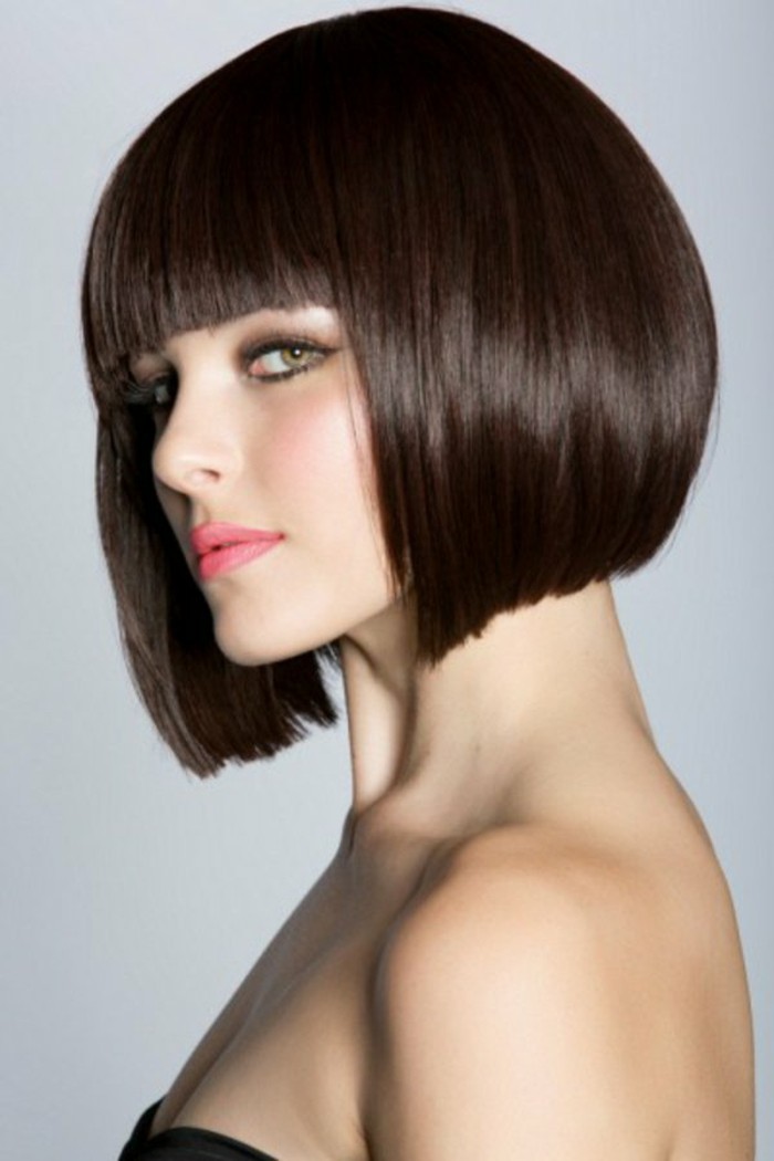 bob with fringe, in dark brunette color, on woman in black strapless top, with coral pink lipstick, and smoky eye make up