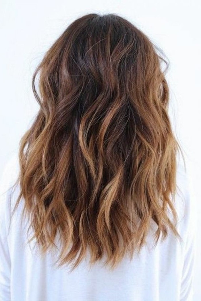 curled hair with blonde balayage, and medium brown hair color, worn by woman in white sweater