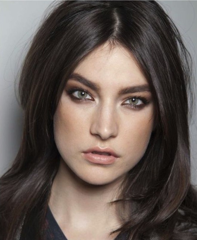 layered hair parted in the middle, dark brown hair colors, worn by green-eyed woman, with smoky eye make up, and nude lipstick