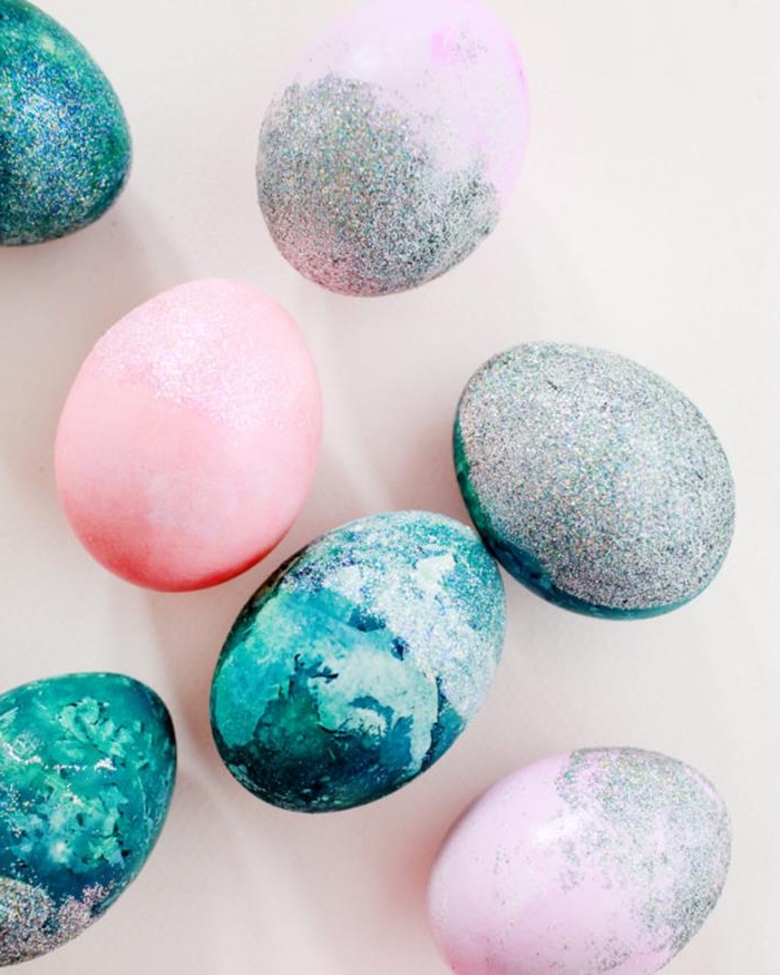 pastel colored easter eggs, in ocean blue and pale pink, some covered in silver iridescent glitter