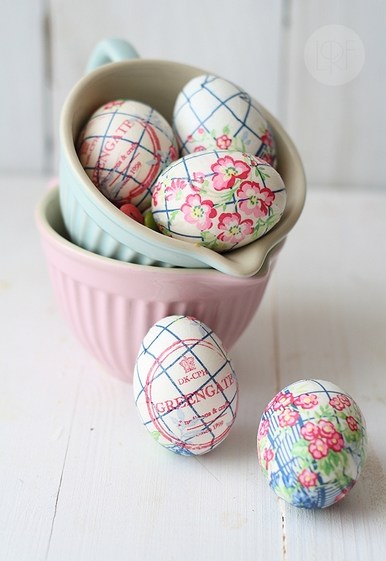 pastel pink and blue jugs, containing three white eggs, decorated with paper napkin decoupage, coloring easter eggs, two more eggs are placed outside of the jug