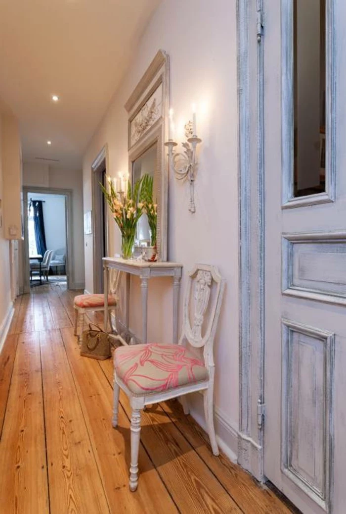 shabby chic pale blue door, solid wooden floorboards, small white antique table with two matching chairs, near a large mirror, and wall candleholder with lit candles, hallway design ideas