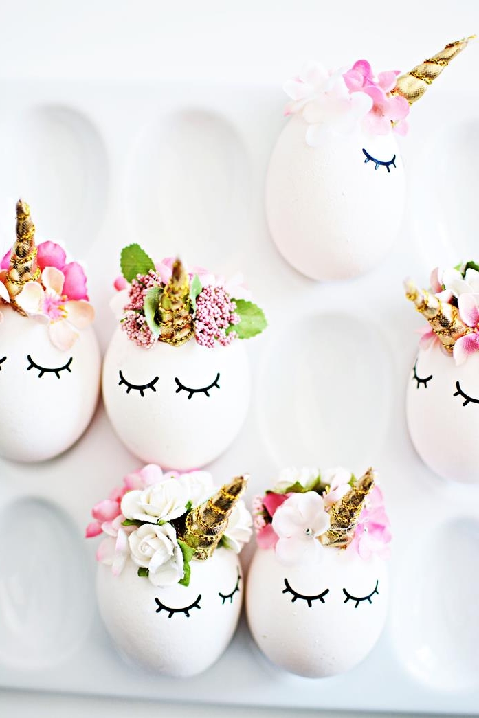 six finished unicorn decorated eggs, dying easter eggs, all white with golden horns, closed eye stickers, small artificial flower crowns