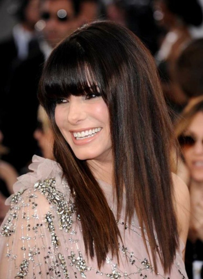 smooth straight dark hair, with long bangs and, and reddish-brown highlights, on sandra bullock, dark haired actresses, wearing pale pink, semi-sheer dress, with silver beads