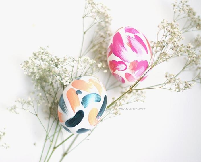 delicate white flowers, near two white eggs, decorated with paint daubs, in hot pink, peach and navy, how to dye easter eggs