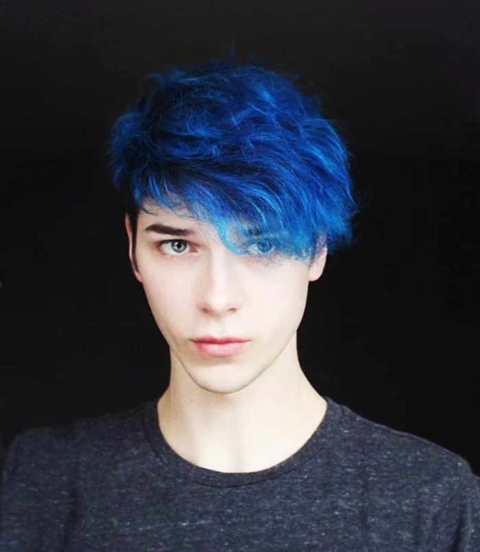 blue curly hair, with long bangs falling over one eye, long hairstyles for boys, on teenager in dark grey t-shirt
