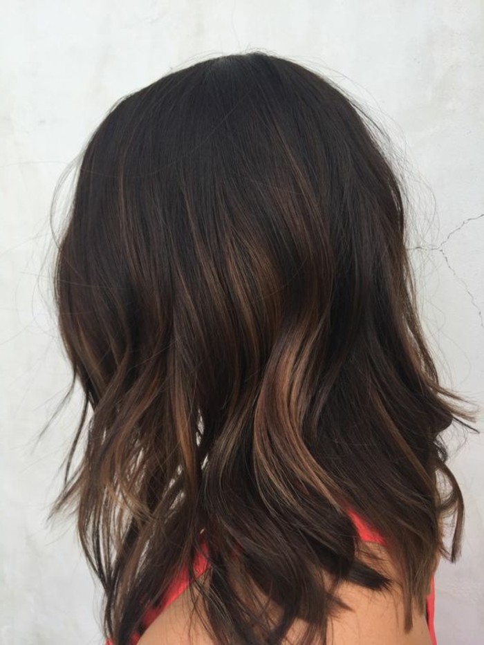 dark brown hair colors, wavy dark chocolate-colored hair, with blonde highlights, worn by woman in red tank-top