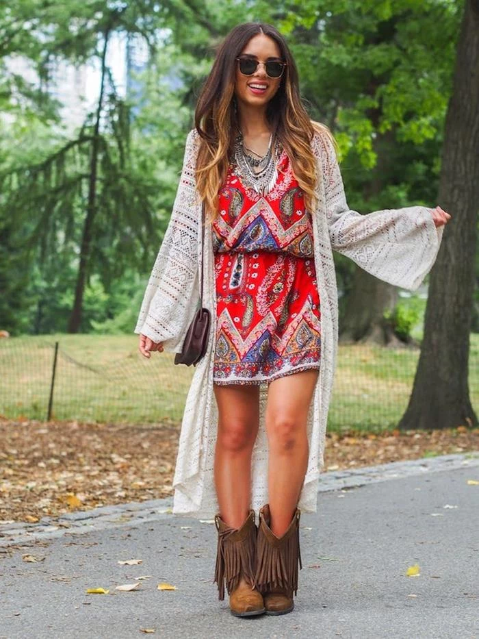 red mini dress, with colorful indian paisley pattern, worn with oversized, pale cream cardigan, tasseled brown calf boots, sunglasses and small bag, bohemian style clothing 