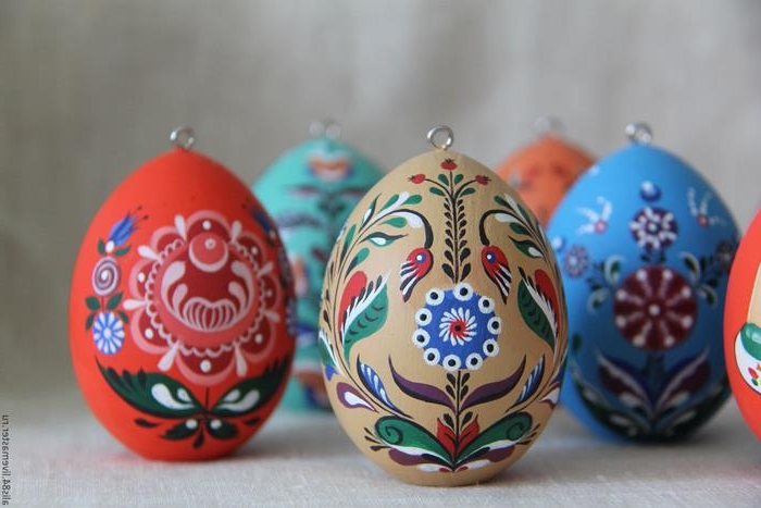 professionally painted easter egg decorations, blue and beige, red and green, with symmetrical floral motifs and patterns, polish or russian