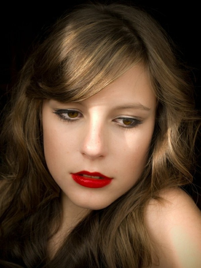 retro black eyeliner, mascara and red lipstick, on young woman, with medium length brown hair, and honey blonde highlights 