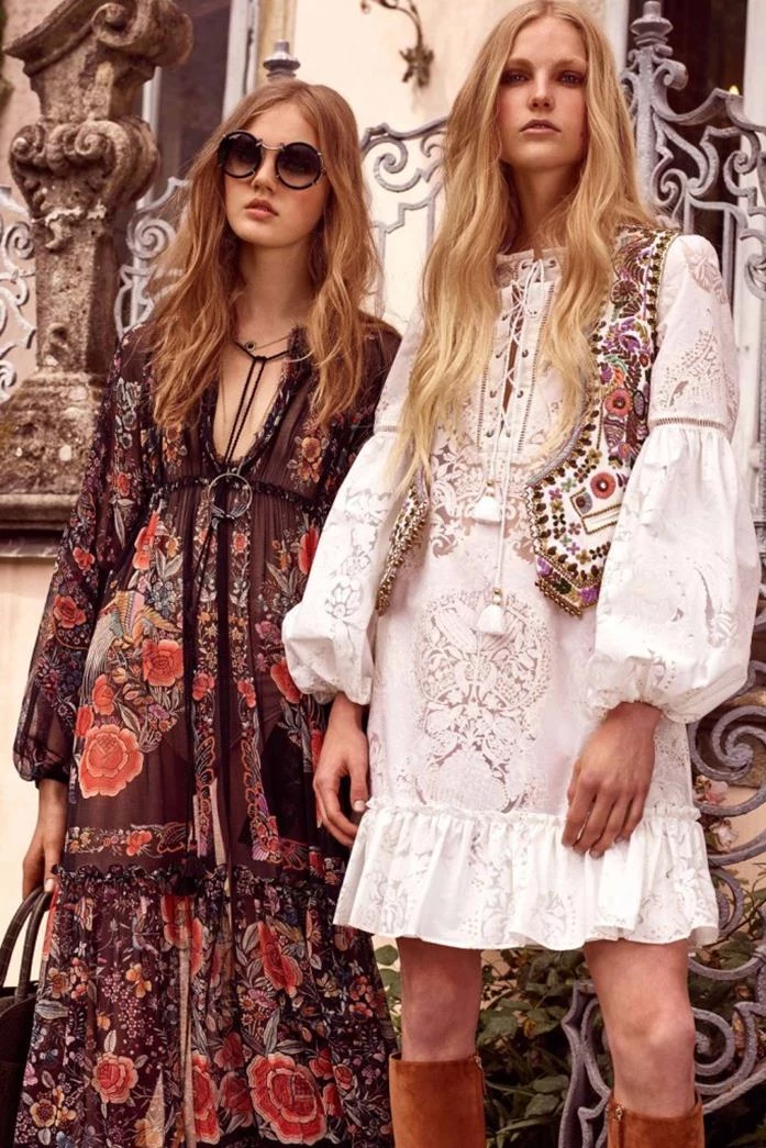 a pair of models, wearing a brown maxi dress, with red flower pattern, and white mini dress, with embroidery and long sleeves, combined with colorful folk vest, retro sunglasses and suede boots