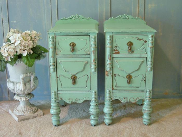 matching small antique cupboards, in mint green, country chic décor, placed on a pale beige carpet, near a vase with white flowers