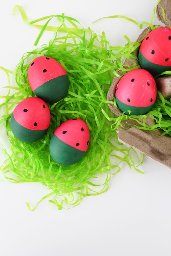 hot pink and dark green easter eggs, painted to look like watermelon slices, easter egg ideas, placed on green easter grass