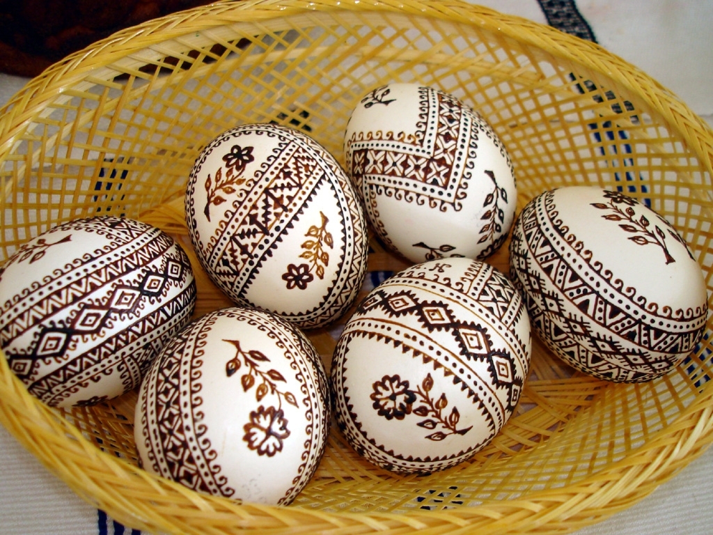 henna drawings with complex patterns on six white eggs, how to dye easter eggs, placed inside a wicker basket
