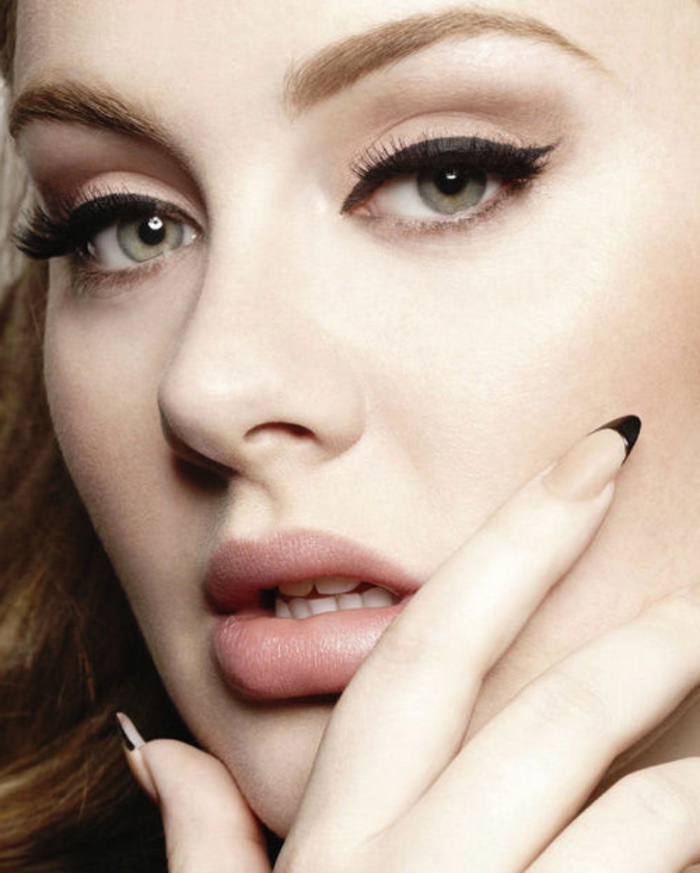 black eyeliner and discreet make-up, on adele seen in close up, nude beige pointy nails, with sharp black tips