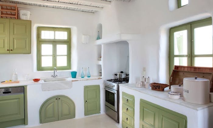 peasant style room, with light pastel green, rustic kitchen cabinets, and matching window panes, white lime plaster walls