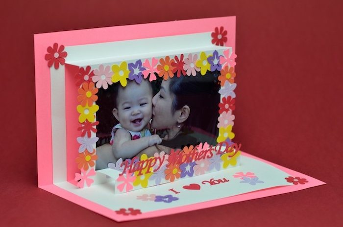 3D effect card, in neon pink and white, last minute mother's day gift ideas, decorated with small paper flowers, image of smiling baby, kissed by mom