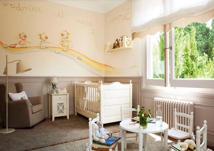 beige carpets and armchair, in baby nursery, with yellow walls, decorated with light brown, yellow and blue mural, white wooden crib, small table and four chairs
