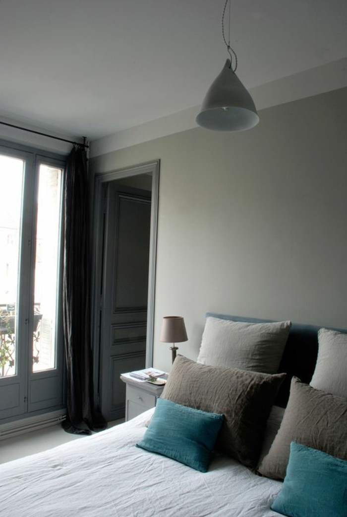pale grey bedroom, bed with pillows in beige and turquoise, minimalistic design and decoration