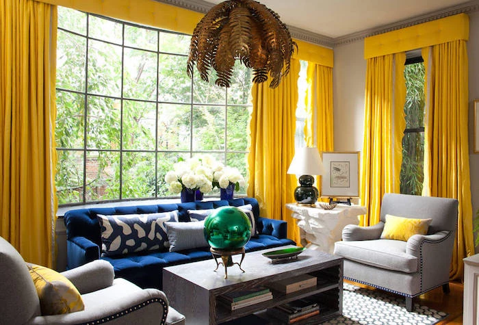 bright yellow curtains, in room with large windows, living room color ideas, navy sofa and light gray armchairs, massive wooden coffee table