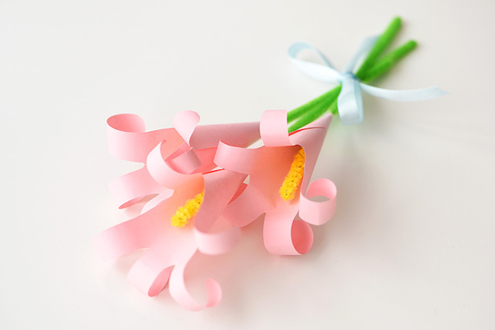 bunch of lilies, made from pale pink, rolled and folded paper, easter diy, with green and yellow, fuzzy wire stalks