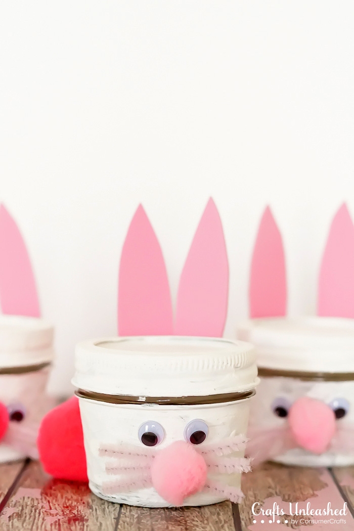 gift mason jars, painted white, and made to look like bunnies, placed on wooden surface, cute easter idea