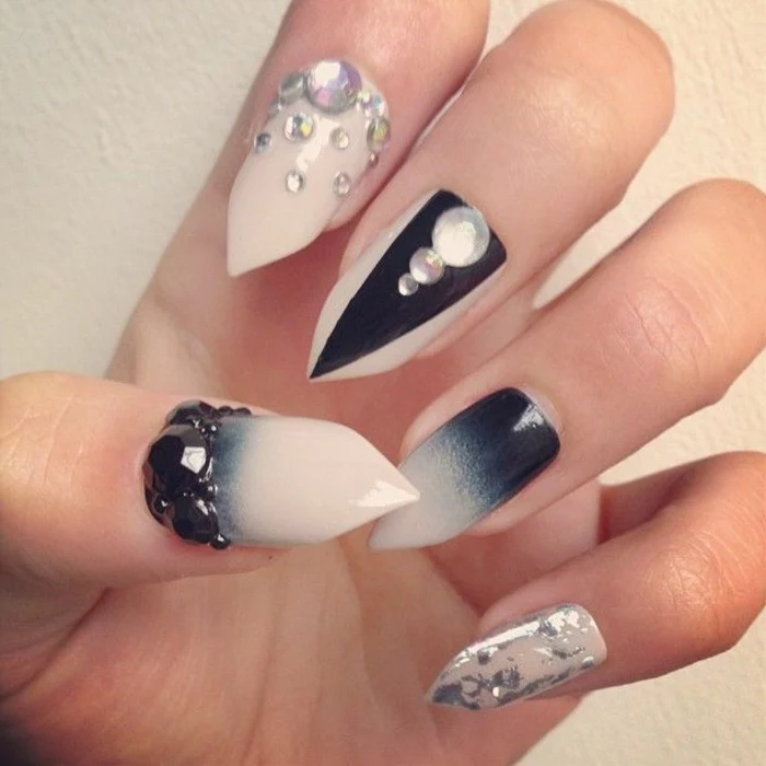 cream and black stiletto nails, decorated with silver and black rhinestones, silver leaf and ombre effect, black triangular shape