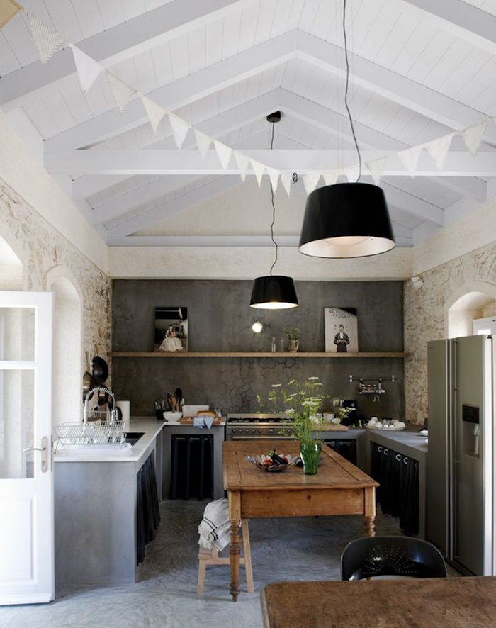 modern and rustic kitchen combination, vintage wooden kitchen island and dining table, gray wall with wooden shelf, white vaulted ceiling 